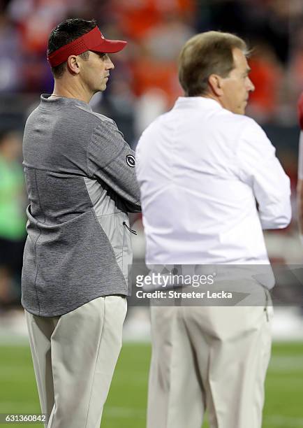Offensive coordinator Steve Sarkisian of the Alabama Crimson Tide stands alongside head coach Nick Saban before taking on the Clemson Tigers in the...
