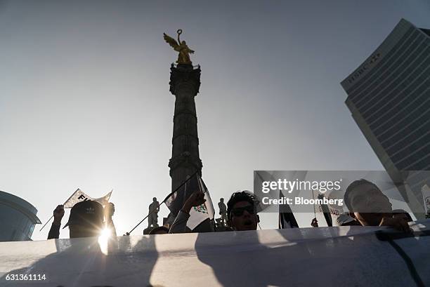 Demonstrators gather and hold signs during a protest against the gasoline price hike in Mexico City, Mexico, on Monday, Jan. 9, 2017. The government...