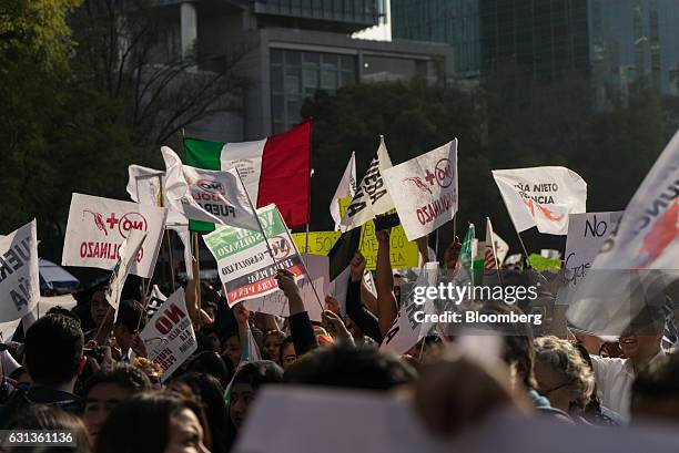 Demonstrators gather and hold signs during a protest against the gasoline price hike in Mexico City, Mexico, on Monday, Jan. 9, 2017. The government...