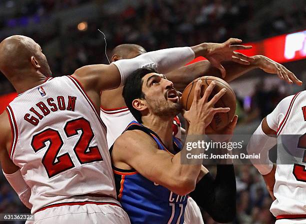 Enes Kanter of the Oklahoma City Thunder tries to get off a shot against Taj Gibson and Cristiano Felicio of the Chicago Bulls at the United Center...