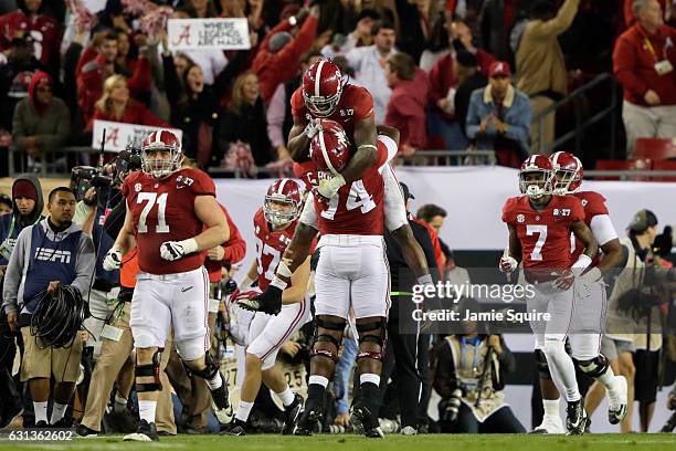 Running back Bo Scarbrough of the Alabama Crimson Tide celebrates with offensive lineman Cam Robinson after rushing for a 37-yard touchdown during...