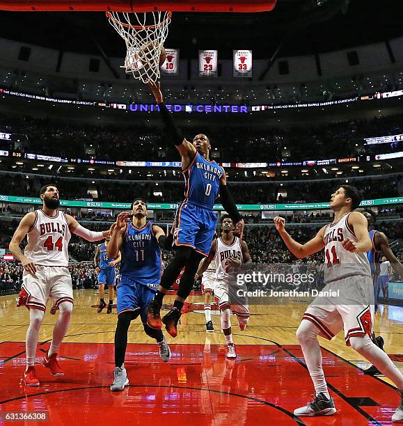 Russell Westbrook of the Oklahoma City Thunder drives the lane between Nikola Mirotic and Doug McDermott of the Chicago Bulls at the United Center on...