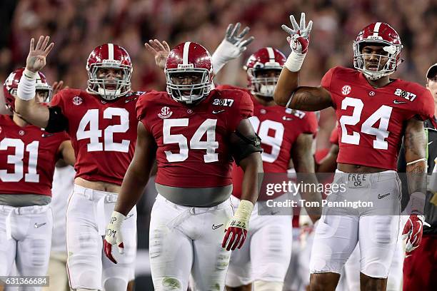 Linebacker Keith Holcombe, defensive lineman Dalvin Tomlinson, and linebacker Terrell Hall of the Alabama Crimson Tide react during the second half...