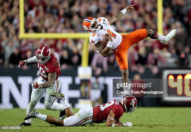 Quarterback Deshaun Watson of the Clemson Tigers is tackled short of the first down by linebacker Reuben Foster and defensive back Minkah Fitzpatrick...