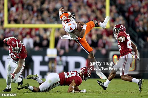 Quarterback Deshaun Watson of the Clemson Tigers is tackled short of the first down by linebacker Reuben Foster and defensive back Minkah Fitzpatrick...