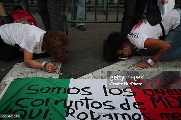 Women kiss the feet of Demonstrators wearing masks of the ex president Salinas De Gortari and the Mexican president Enrique Peña Nieto outside...