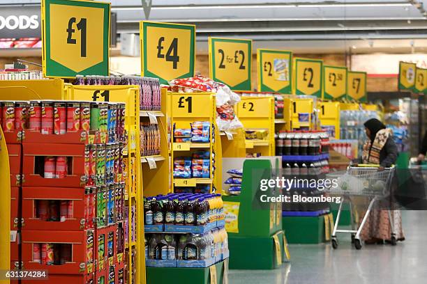 Price signs stand above displays of goods at the ends of aisles inside a Morrisons supermarket, operated by Wm Morrison Supermarkets Plc, in London,...