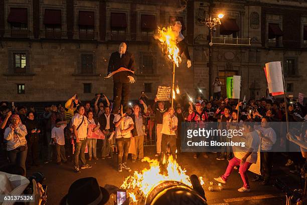Demonstrators burn effigies of Mexico's President Enrique Pena Nieto, right, and U.S. President-elect Donald Trump during a protest against the...