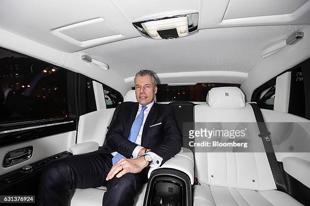 Torsten Mueller-Oetvoes, chief executive officer of Rolls-Royce Motor Cars Ltd., poses for a photograph inside a Rolls Royce Phantom vehicle...
