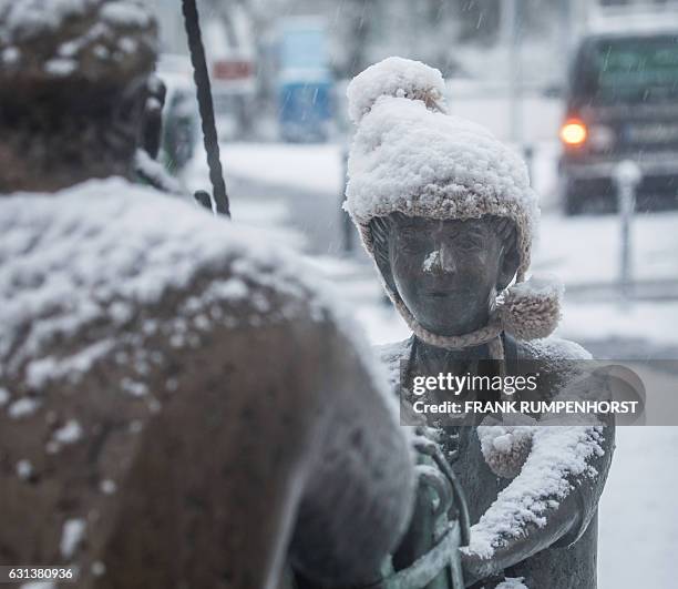 Statue decorating a fountain wears a cap covered in snow in Bad Vilbel near Frankfurt am Main, western Germany, on January 10, 2017. / AFP / dpa /...