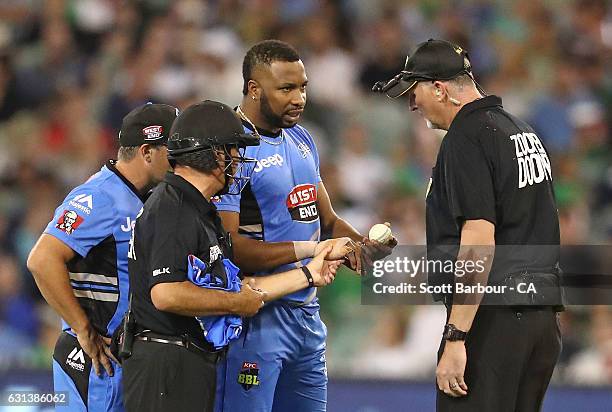 The umpires inspect the taping on the hand of bowler Kieron Pollard of the Strikers during the Big Bash League match between the Melbourne Stars and...