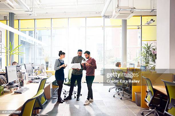 colleagues having an impromptu meeting. - business desk stock pictures, royalty-free photos & images