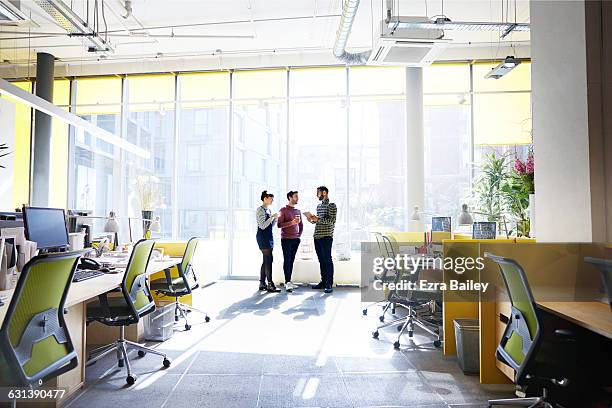 creative colleagues stand talking about ideas. - person standing far stock pictures, royalty-free photos & images