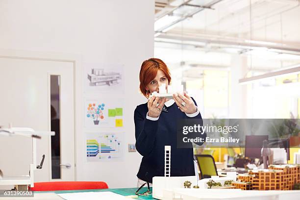 designer examines a model in open plan office - replica stock pictures, royalty-free photos & images