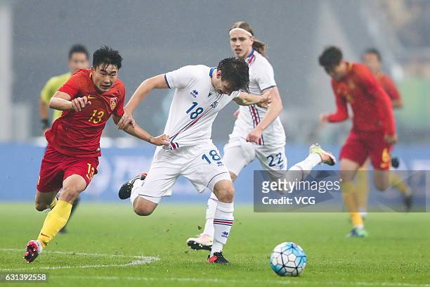 Deng Hanwen of China and Elmar Bjarnason of Iceland compete for the ball during the 2017 China Cup International Football Championship match between...