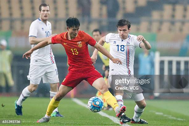 Deng Hanwen of China and Elmar Bjarnason of Iceland compete for the ball during the 2017 China Cup International Football Championship match between...