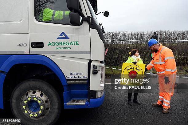 Member of security staff talks with an anti-fracking protester standing in front of a truck delivering gravel to the Preston New Road site where...