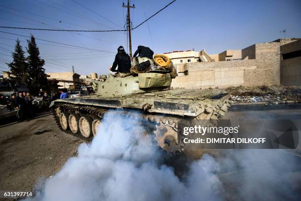 An Iraqi army T-72 tank heads to the frontline during a battle against the Islamic State group near the Fourth Bridge over the Tigris River...