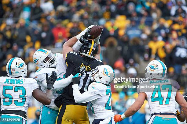 Pittsburgh Steelers tight end Jesse James jumps to reach a tipped ball amongst defenders during a NFL AFC Wild Card football game between the...