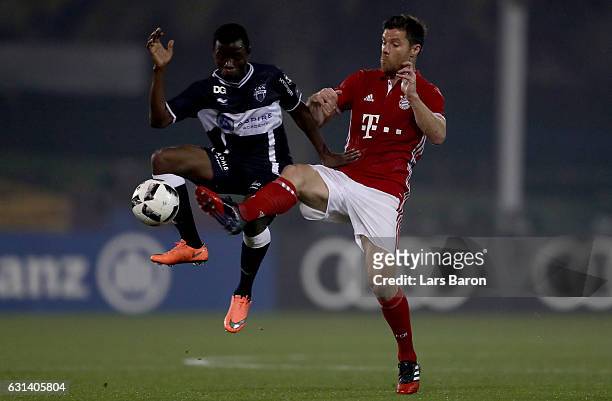 Odeni George of Eupen is challenged by Xavi Alonso of Muenchen during the friendly match between Bayern Muenchen and KAS Eupen on January 10, 2017 in...