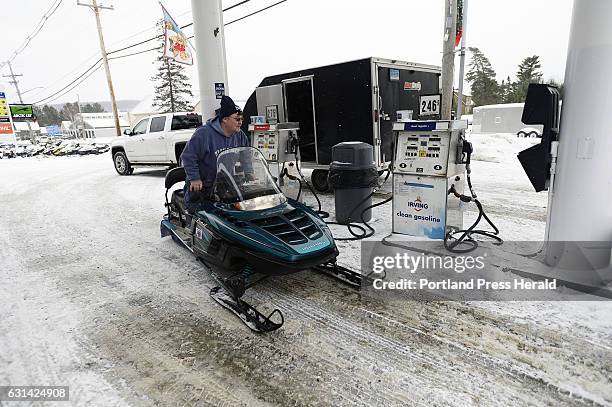 Steve Hogan of Waterford, Connecticut rides off on his snowmobile after getting gas at Loony Bin Variety on Main St. In Rangeley Wednesday, December...