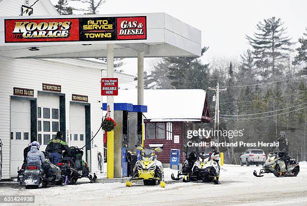 Snowmobilers line up for gas at Koob's Garage in the village of Oquossoc in the town of Rangeley Wednesday, December 28, 2016.