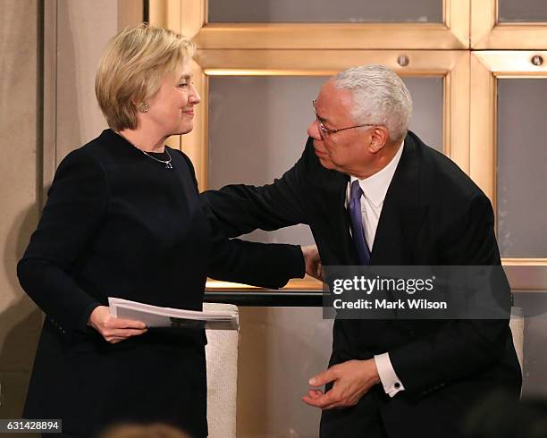 Former Secretary of State, Colin Powell , stands up to give a kiss to former Secretary of State Hillary Clinton after she spoke at a reception...