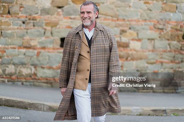 Alessandro Squarzi is wearing a brown checked coat, white pant on January 10, 2017 in Florence, Italy.