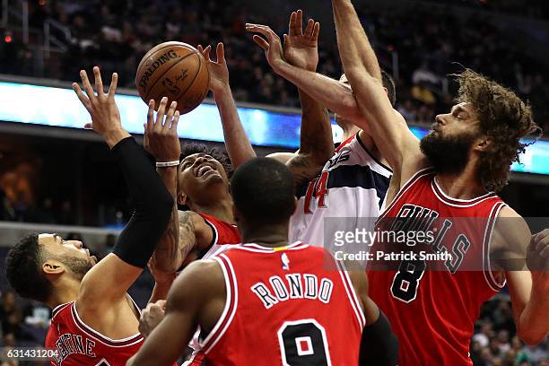 Kelly Oubre Jr. #12 of the Washington Wizards pulls in a rebound in front of Denzel Valentine and Robin Lopez of the Chicago Bulls during the first...