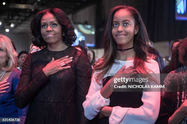 First Lady Michelle Obama and daughter Malia listen to the national anthem before President Barack Obama delivered his farewell address in Chicago,...