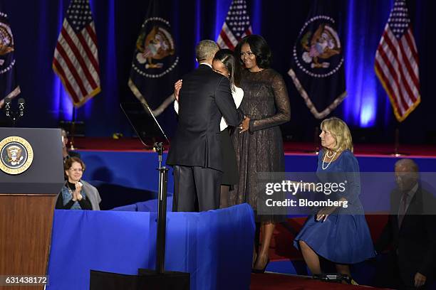 President Barack Obama, center left, embraces his daughter Malia Obama as U.S. First Lady Michelle Obama, center right, looks on while U.S. Vice...