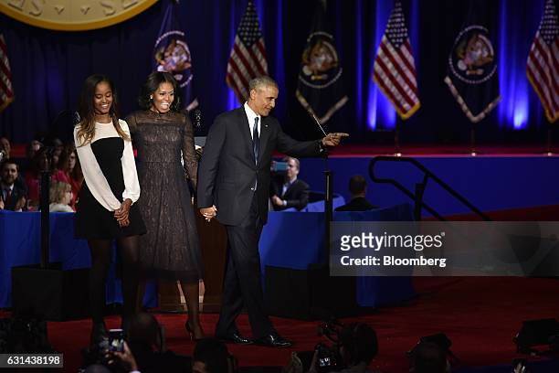 President Barack Obama, right, gestures as U.S. First Lady Michelle Obama, center, and their daughter Malia Obama look on after his farewell address...