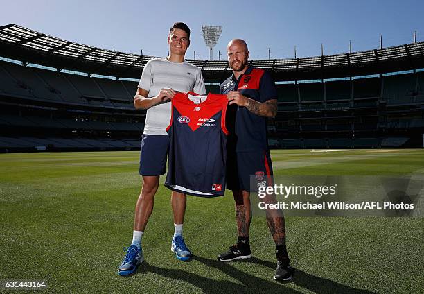 Canadian tennis player Milos Raonic and Melbourne AFL captain Nathan Jones pose for a photograph during a Melbourne Demons AFL media opportunity at...