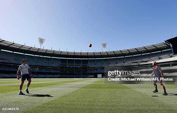 Canadian tennis player Milos Raonic and Melbourne AFL captain Nathan Jones kick the football during a Melbourne Demons AFL media opportunity at...