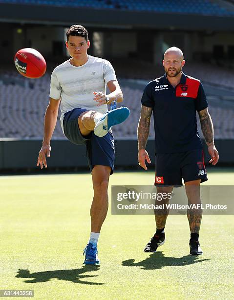 Canadian tennis player Milos Raonic and Melbourne AFL captain Nathan Jones kick the football during a Melbourne Demons AFL media opportunity at...