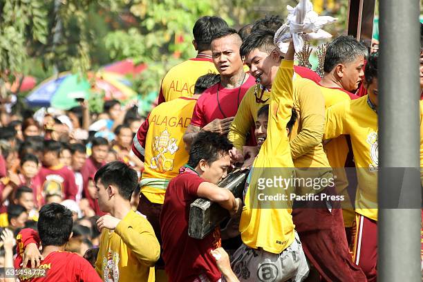 Devotee cheers wildly after being able to kiss the cross of the miraculous Icon of the Black Nazarene while another reverently kisses the same....