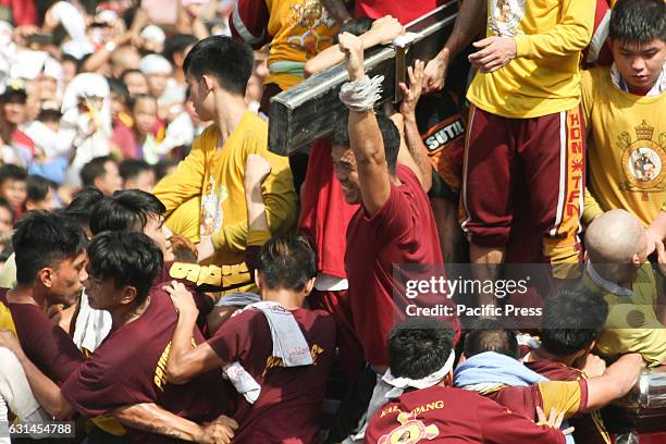 Devotee cheers wildly after being able to kiss the cross of the miraculous Icon of the Black Nazarene. Devotees observe this tradition of touching...