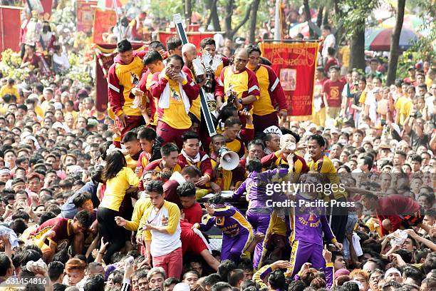 Devotees clamber over one another in an attempt to be able to touch the image of the Black Nazarene during the Traslacion of the Icon from the...