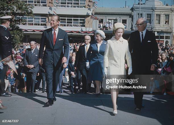Queen Elizabeth II and the Duke of Edinburgh are shown around the State Library of Victoria and various museums in Melbourne by Dr Louis Matheson ,...
