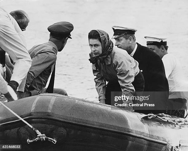 Queen Elizabeth II and the Duke of Edinburgh disembark from the royal yacht 'Britannia' at Ship Cove, during the royal tour of New Zealand, 18th...