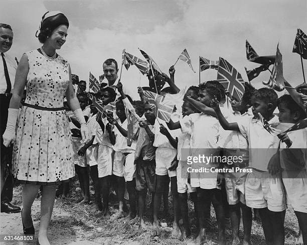 Queen Elizabeth II is greeted by local children at Cooktown in Queensland, during her tour of Australia, 22nd April 1970. She is there in connection...