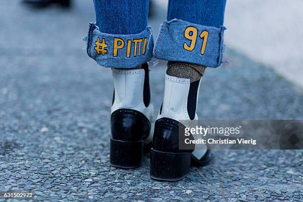 Guest wearing jeans with the print Pitti Uomo 91 on January 11, 2017 in Florence, Italy.