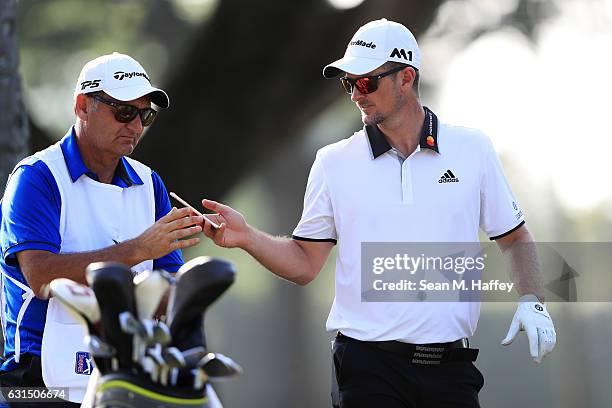 Justin Rose of England talks with his caddie Mark Fulcher during the Pro-Am Tounament prior to the Sony Open In Hawaii at Waialae Country Club on...