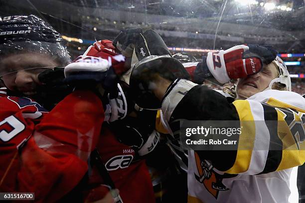 Evgeny Kuznetsov of the Washington Capitals and Carl Hagelin of the Pittsburgh Penguins fight in the third period at Verizon Center on January 11,...