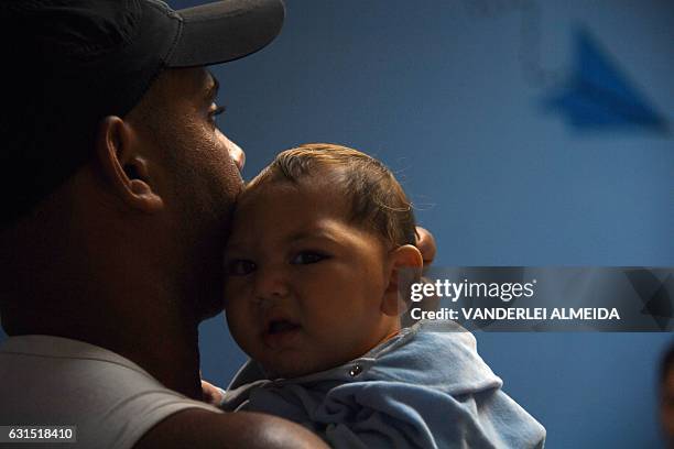 Paulo Sergio holds his six-month-old baby Arthur Meneses as they wait for medical exams at the State Brain Institute in Rio de Janeiro, Brazil on...