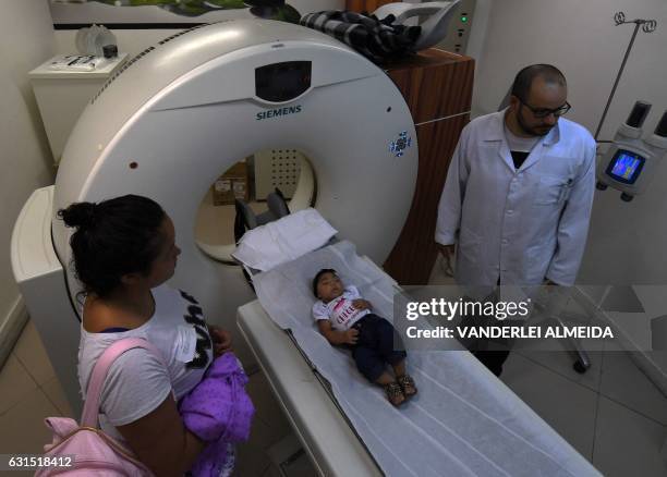 Brenda Pereira stands by her four-month-old baby Maria Fernanda as she is examined at the State Brain Institute in Rio de Janeiro, Brazil on January...