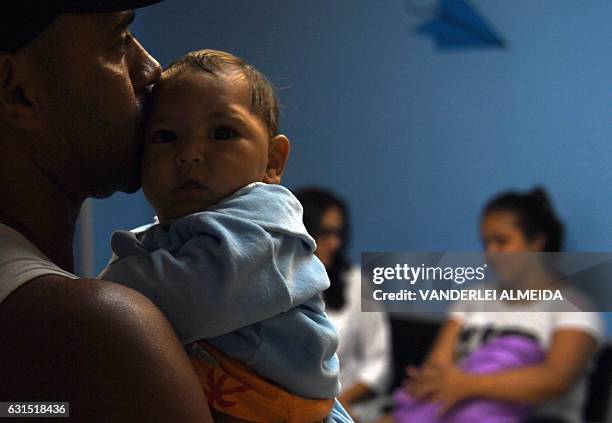 Paulo Sergio holds his six-month-old baby Arthur Meneses as they wait for medical exams at the State Brain Institute in Rio de Janeiro, Brazil on...