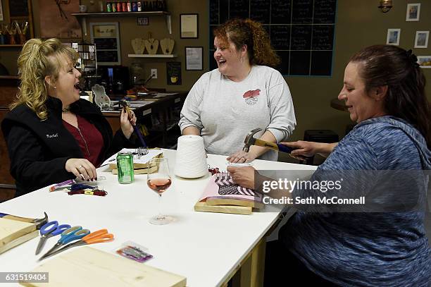 Mary-Ruth Tracy, center, laughs as she chats with Rachel Munoz Florido, left, and Karen Kucera as they make string art at Tracy's Place in Arvada,...