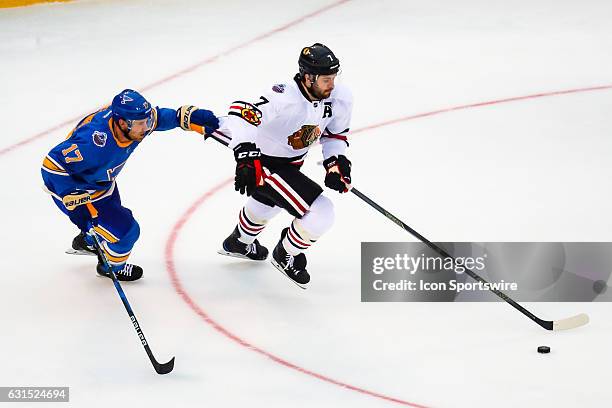 St. Louis Blues Left Wing Jaden Schwartz grabs the jersey of Chicago Blackhawks Defenseman Brent Seabrook as he skates up ice during the first period...
