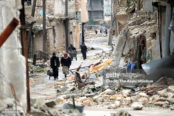 People walk a street on January 10, 2017 in Aleppo, Syria. Bashar al-Assad administration backed by Russia recaptured the area in eastern Aleppo...